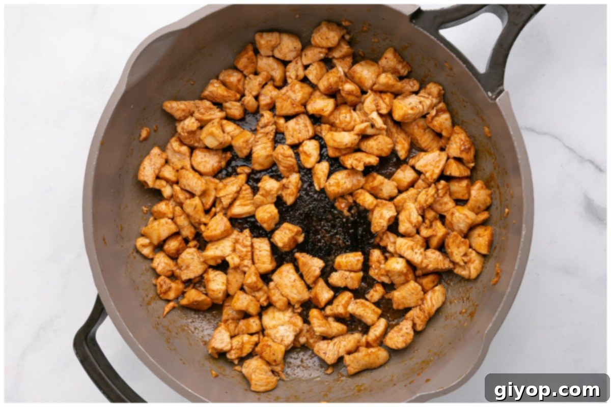 A hot skillet containing perfectly cooked and browned chicken pieces, ready for assembly.