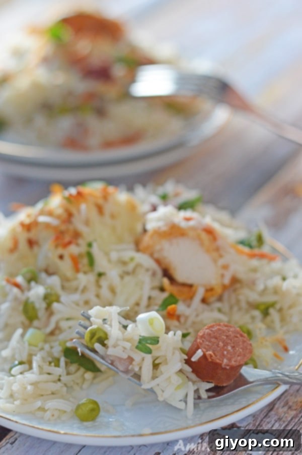 A serving of the Cheesy Chicken and Rice Casserole, with visible chicken, hot dogs, and melted cheese, on a plate.