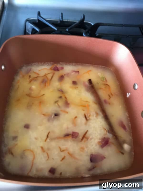 Basmati rice added to the pot with vegetables and spices, before adding water to cook.