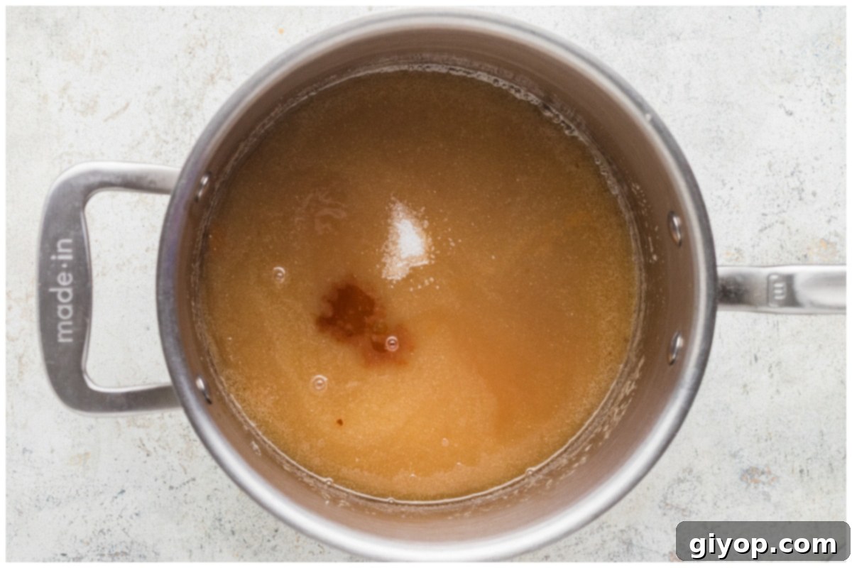 Adding vanilla extract and sea salt to the finished caramel sauce, enhancing its flavor.