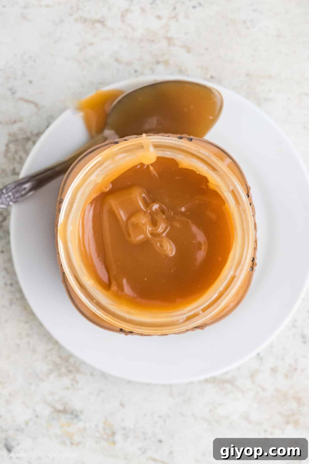 Delicious, golden homemade salted caramel sauce in a jar, perfect for various desserts.