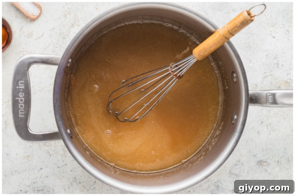 Caramel sauce with a whisk cooking in a saucepan, thickening to the right consistency.