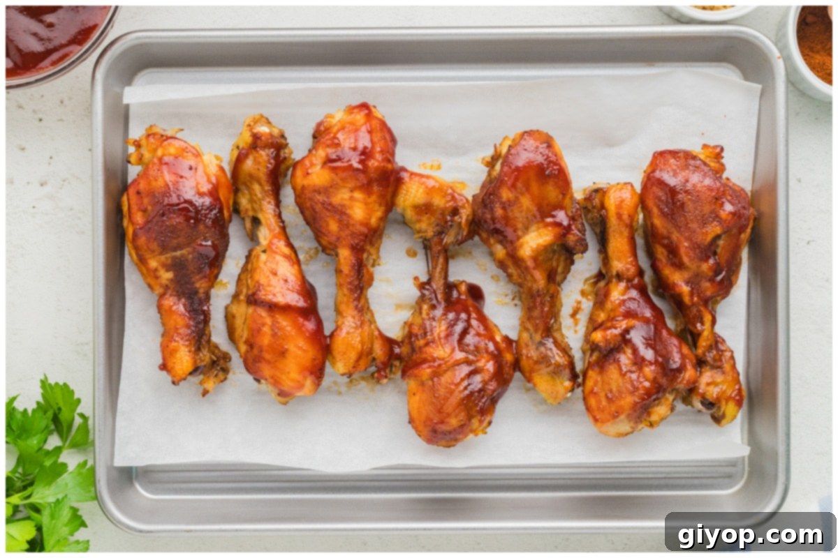 Perfectly broiled and caramelized slow cooker chicken drumsticks resting on a baking sheet before serving.