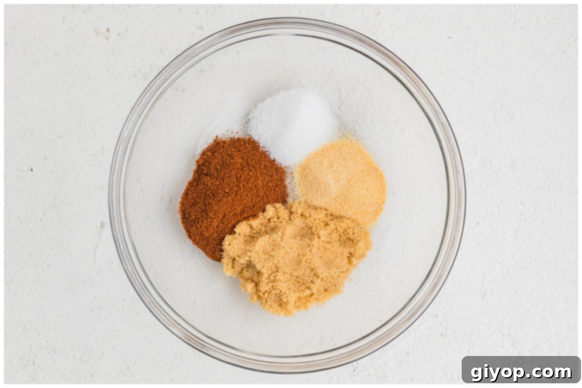 A small glass bowl filled with a blend of smoky paprika, brown sugar, sea salt, and garlic powder.