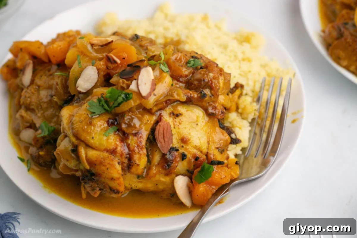 A vibrant close-up image of a Moroccan Chicken Tagine with Apricots simmering in a traditional tagine pot, garnished with fresh herbs.