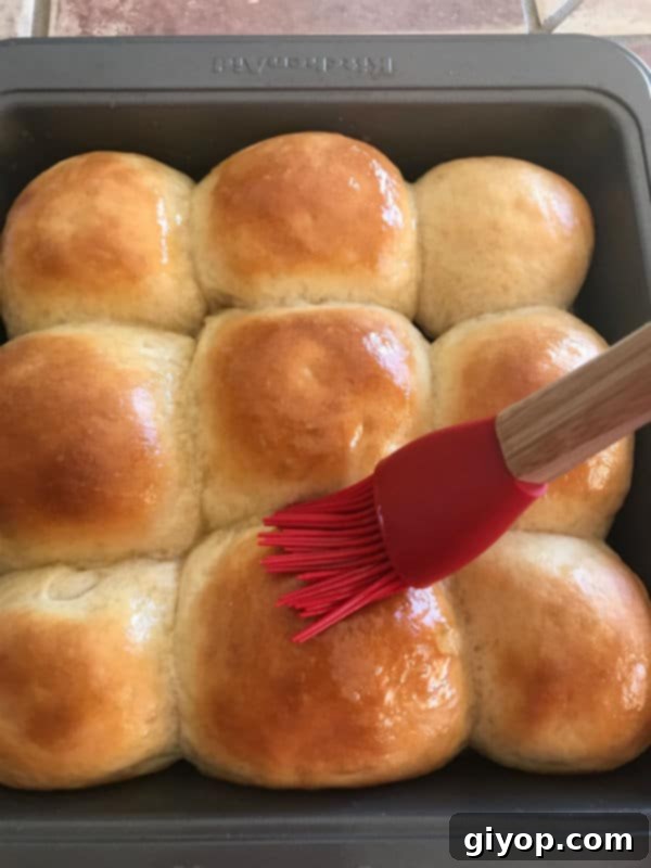 Golden brown dinner rolls fresh out of the oven, brushed with melted butter.