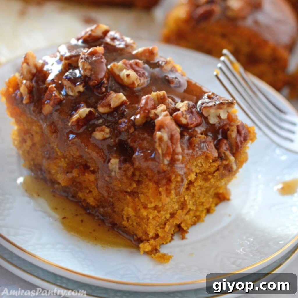 A slice of delectable browned butter pecan pumpkin sheet cake on a white dessert plate, with a fork poised to enjoy.
