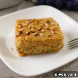 Harissa: Egypt's Fiery Secret 8 A piece of Harissa dessert on a white plate with a fork on the side.