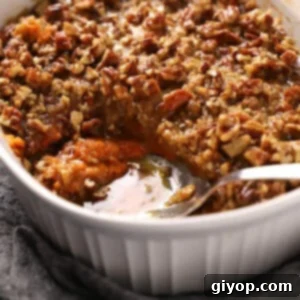 Close up of a spoon serving some sweet potato crunch casserole.