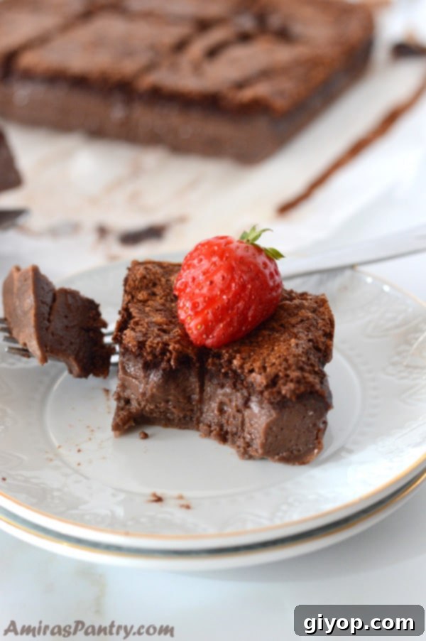 A piece of Chocolate Magic Cake on a plate, highlighting the distinct custard layer in the middle and its rich texture.