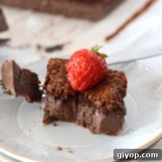 A piece of chocolate cake on a plate with strawberry