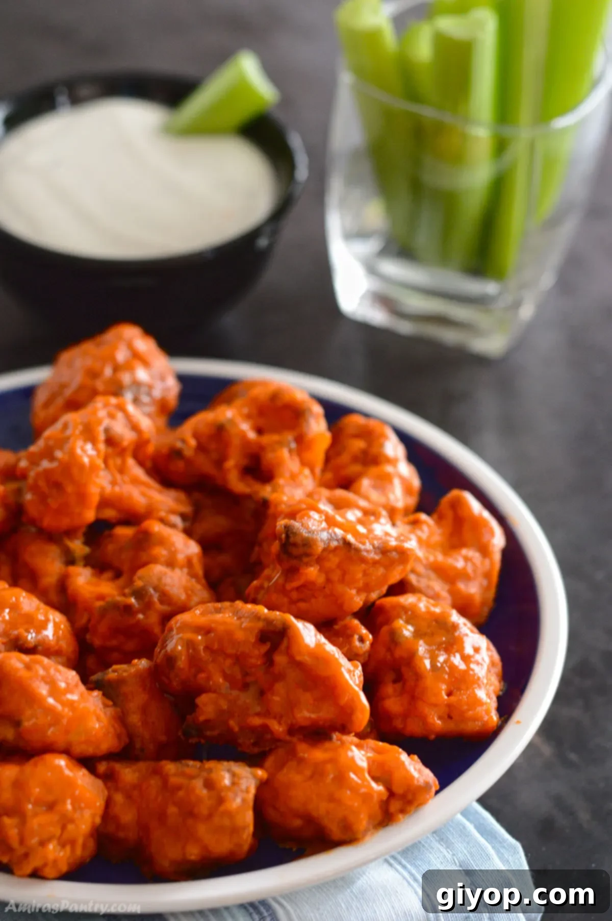 Buffalo Cauliflower Poppers 2 Buffalo cauliflower wings piled up on a blue plate.