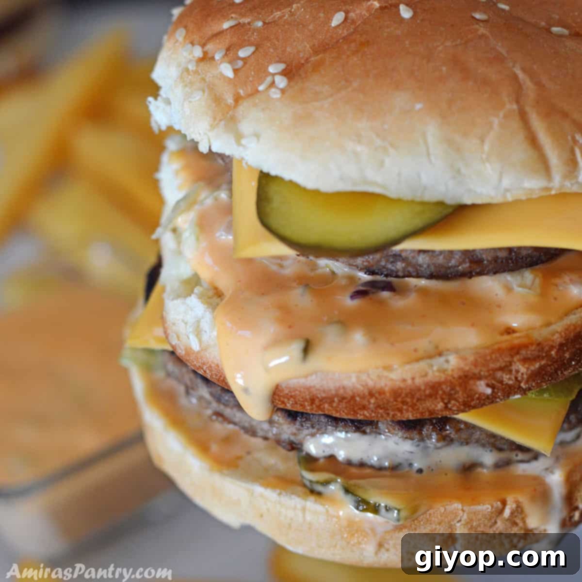 A close up shot for a copy cat big mac sandwich with sauce dripping off.