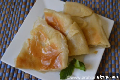 A close up of Pizza feteer topped with butter on a white plate