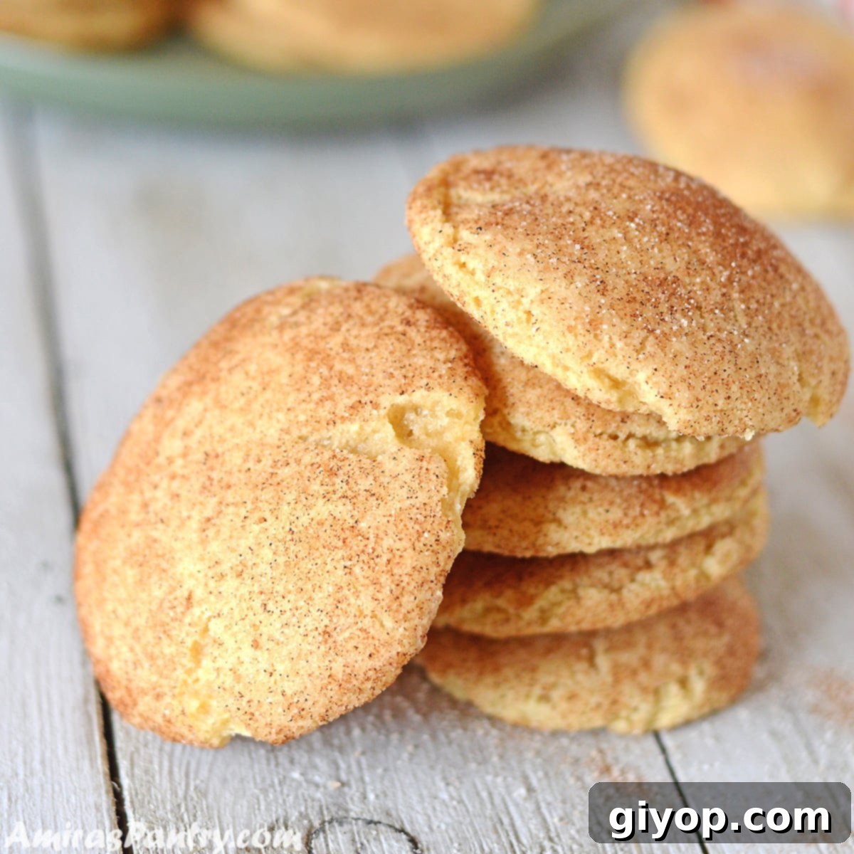 snickerdoodle cookies on a wooden table with one cookie tilted on the side