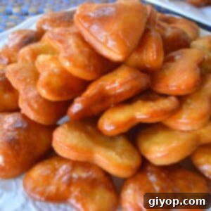 A close up on a plate with golden cheese fritters, ready to be served.
