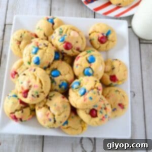Pudding Burst Cookies 7 A white serving plate with M&M cookies and milk on the side.