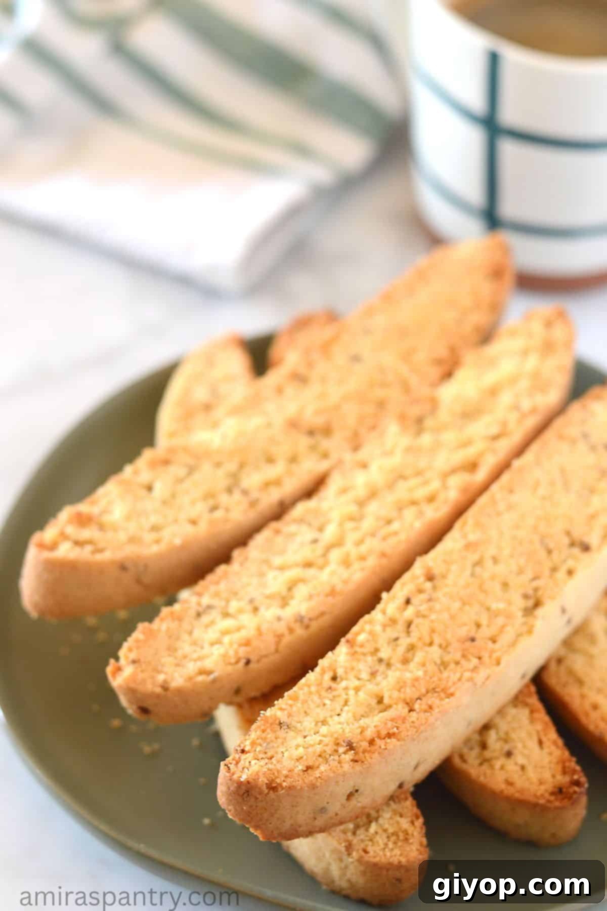 A stack of golden-brown anise biscotti on a vibrant green plate, ready to be enjoyed with a cup of tea or coffee.