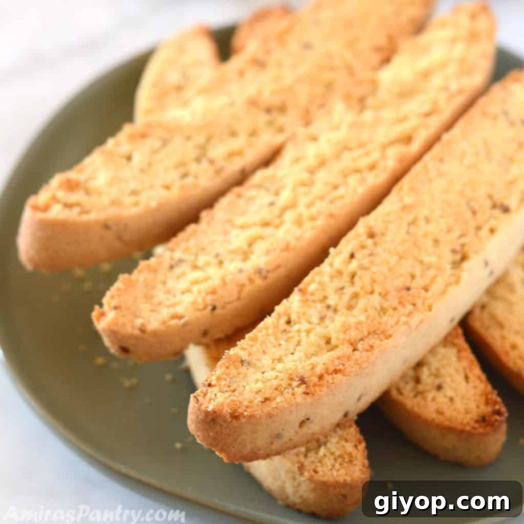 A close-up of golden-brown Anise Biscotti artfully arranged on a white plate, ready for serving.