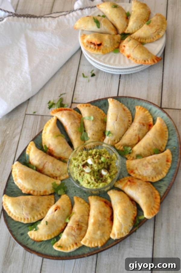 A photo of Empanadas sitting on a plate on a wooden table