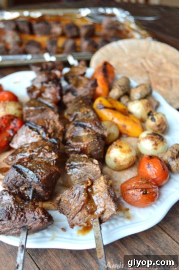 Beef kabob skewers in a plate with pita bread