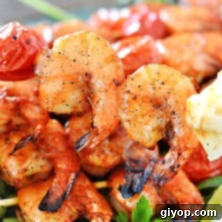 Zesty Grilled Shrimp Skewers 6 A plate of grilled shrimps on skewers with two shrimps in focus.