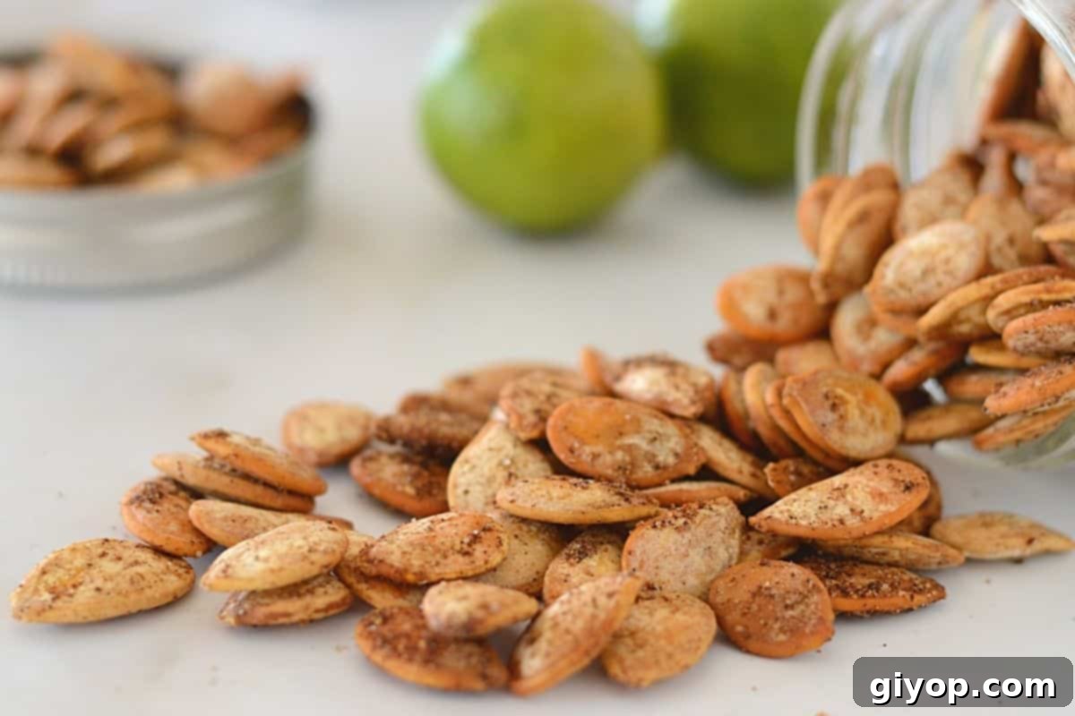 Blazing Pumpkin Seed Crunch 7 Spicy roasted pumpkin seeds falling from a glass jar on a white marble surface.