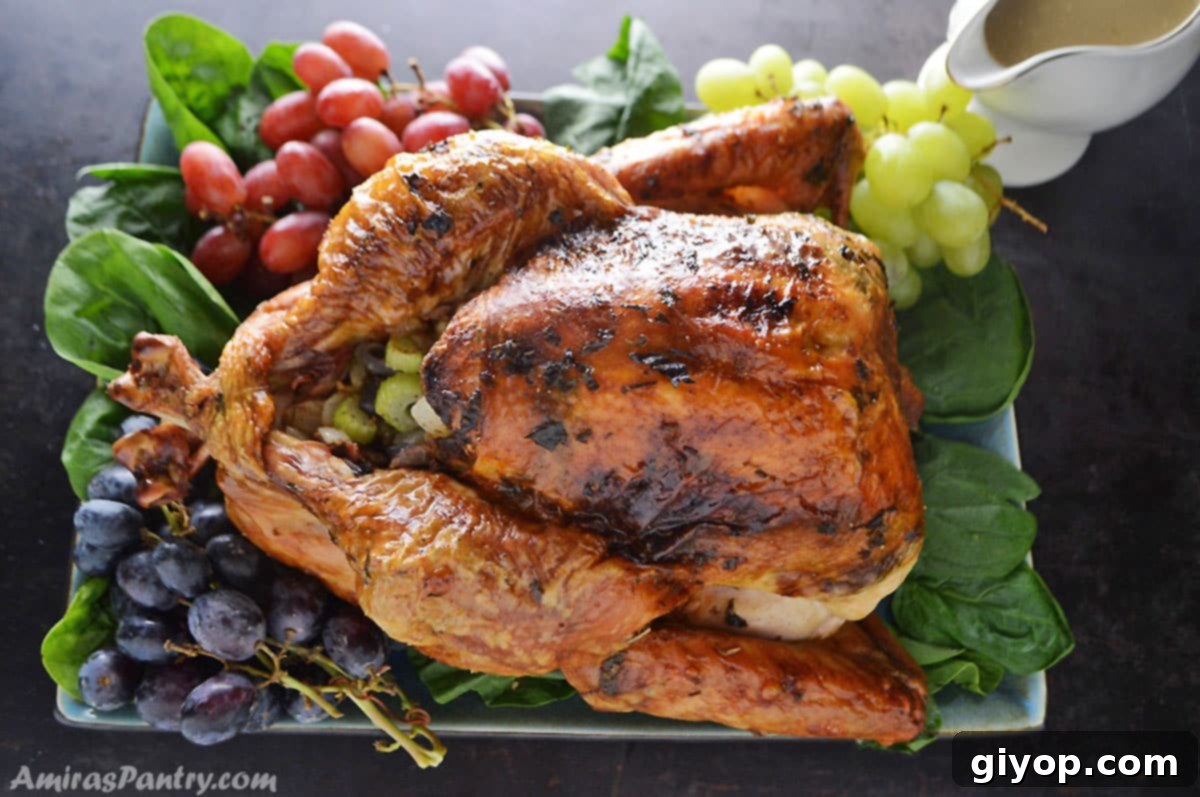 Juicy Roast turkeu placed on a serving platter with greens under it.