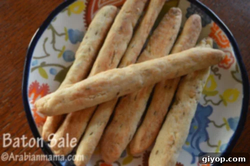 A close up of a plate with bread-sticks