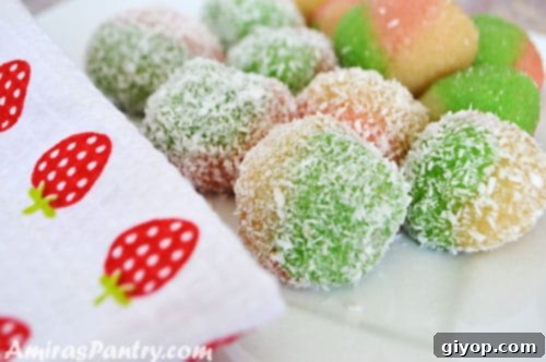 A close-up of beautifully crafted Tunisian almond dessert balls in various colors, showcasing their intricate marbling.