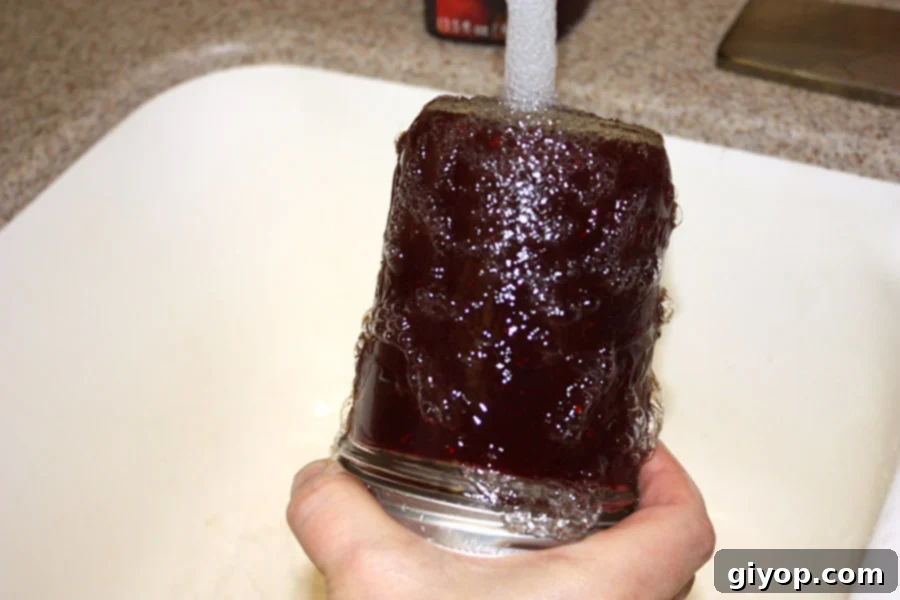 Mason jar upside down under running hot water to loosen cranberry sauce.