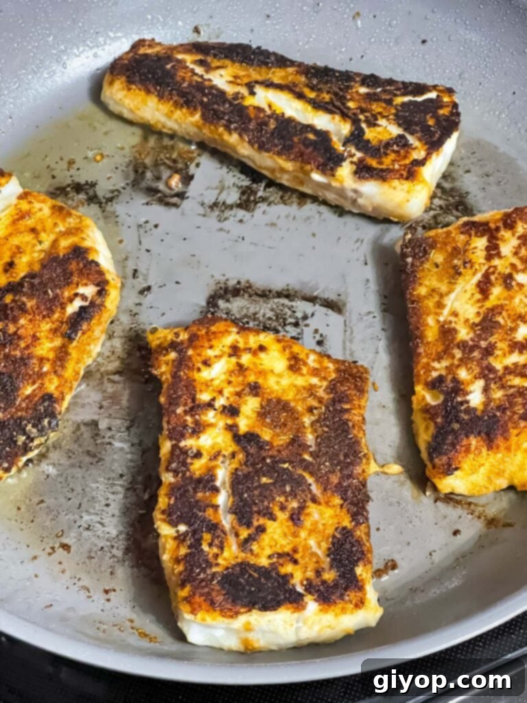 Fiery Blackened Fish Tacos 11 Perfectly blackened fish in a skillet, ready to be removed.