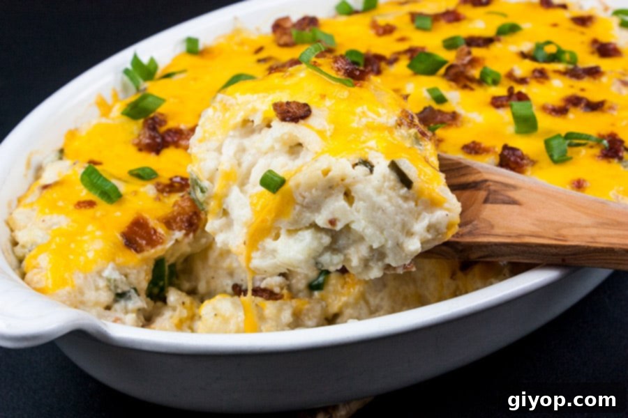 Loaded Cauliflower Mash Casserole - scooped out with a wooden spoon