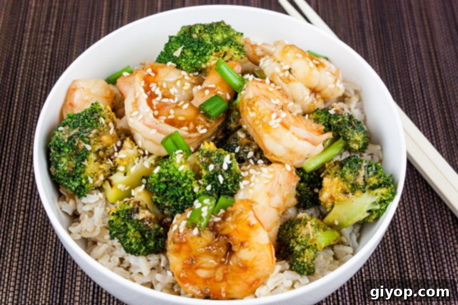 Savory Sesame Shrimp and Broccoli 6 Shrimp and Broccoli Stir Fry in a white bowl with chopsticks, ready to eat.