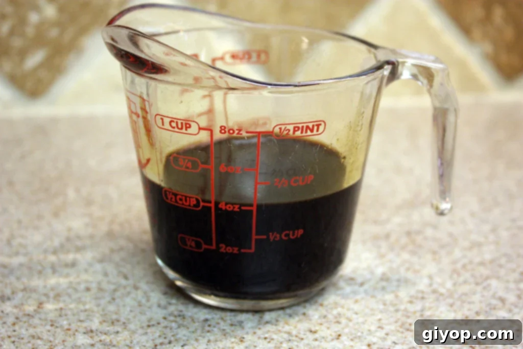 Effortless Tiramisu No Ladyfingers 5 Freshly brewed dark espresso captured in a clear glass measuring cup, ready to be transformed into the aromatic coffee syrup for Tiramisu.