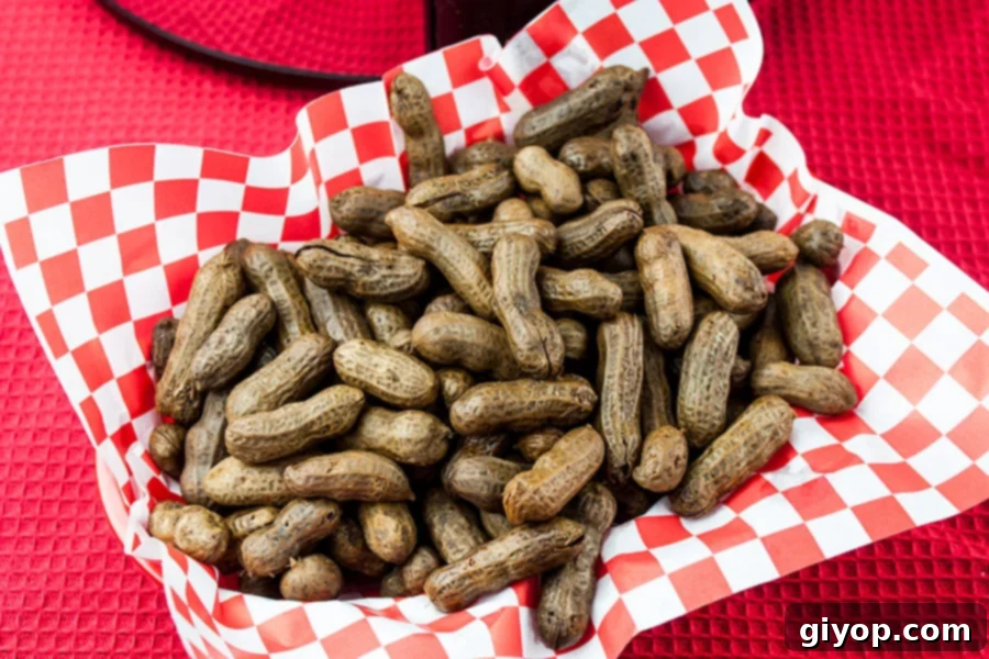Easy Slow Cooker Boiled Peanuts 9 A close-up of a red and white checkered paper-lined basket holding a generous portion of boiled peanuts.