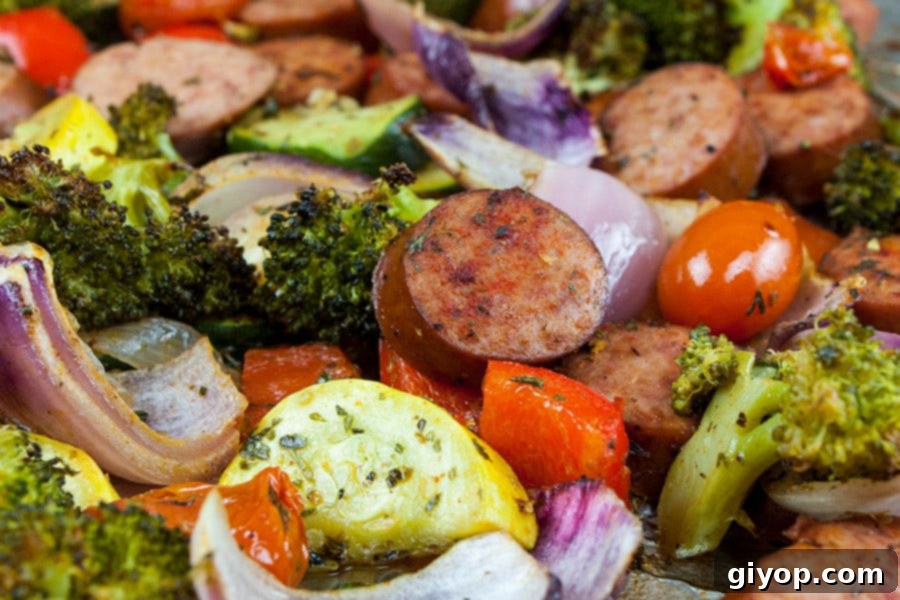 Sheet Pan Sausage and Vegetables mixed together, featuring colorful bell peppers, broccoli, and sliced sausage.
