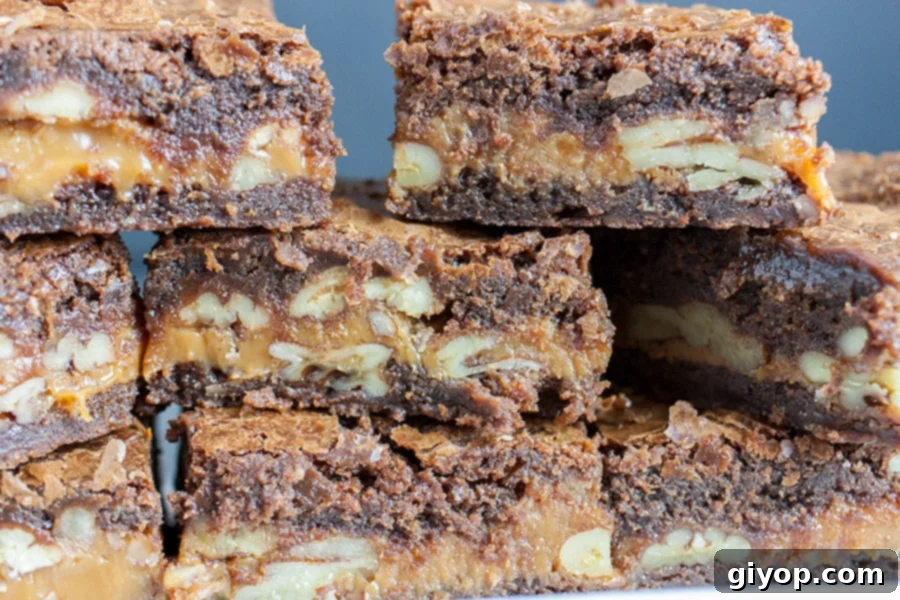 Supreme Turtle Indulgence 2 Stacked fudgy turtle brownies oozing with caramel and pecans, showcasing their rich layers.