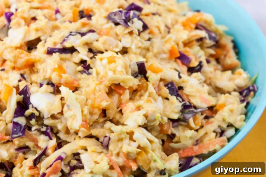 A large blue bowl filled with vibrant Tangy Southern Mustard Coleslaw, ready to be served.