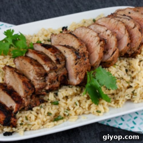 Perfectly Grilled Adobo Pork Tenderloin 3 Grilled Adobo Pork Tenderloin - Sliced pork tenderloin on a bed of cilantro lime rice.