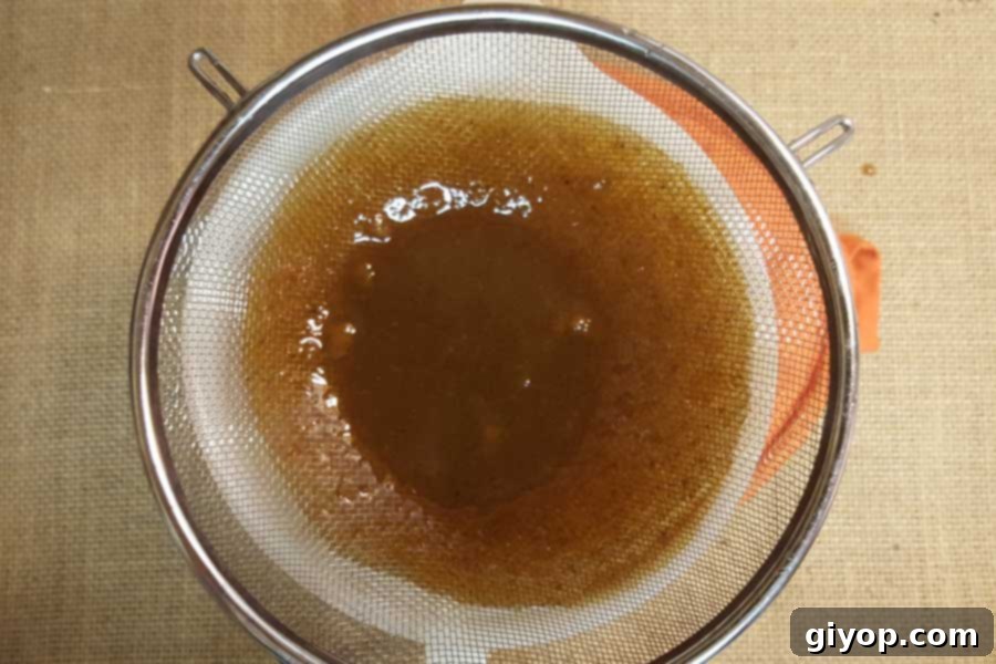 Pumpkin spice syrup in a strainer.