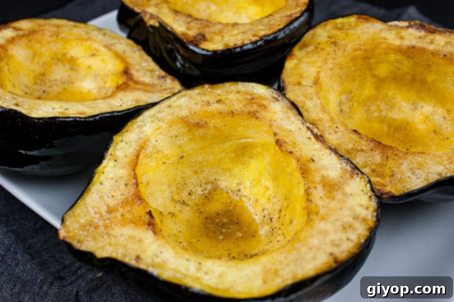 Perfectly Roasted Acorn Squash Recipe 2 Perfectly roasted acorn squash halves garnished with fresh herbs on a white platter, ready to be served as a delightful side dish.