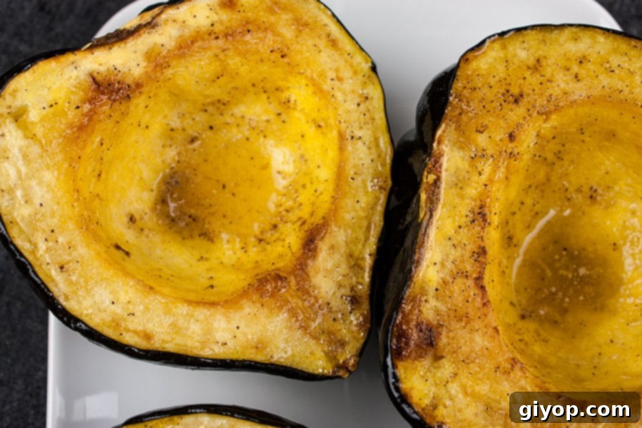 Perfectly Roasted Acorn Squash Recipe 5 A close-up view of a roasted acorn squash half, showcasing its tender, slightly caramelized flesh on a white plate, invitingly delicious.