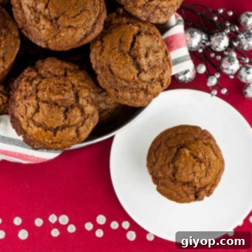 Gingerbread muffins in a basket lined with red, white, and green towel, a delicious holiday treat.