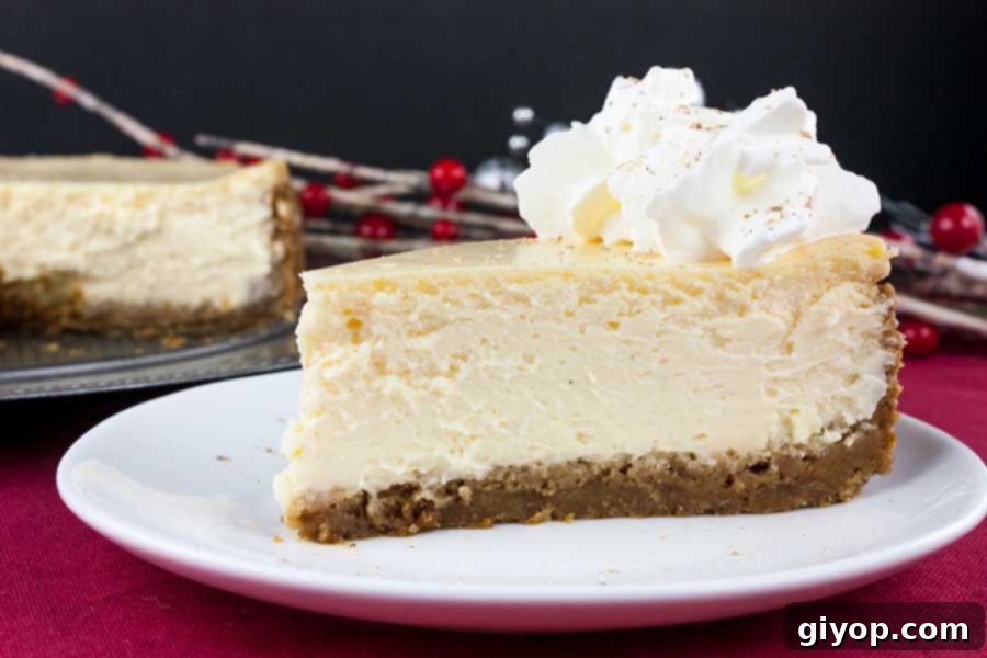 A delectable slice of eggnog cheesecake, generously garnished with fresh whipped cream and a dusting of nutmeg, served on a pristine white plate.