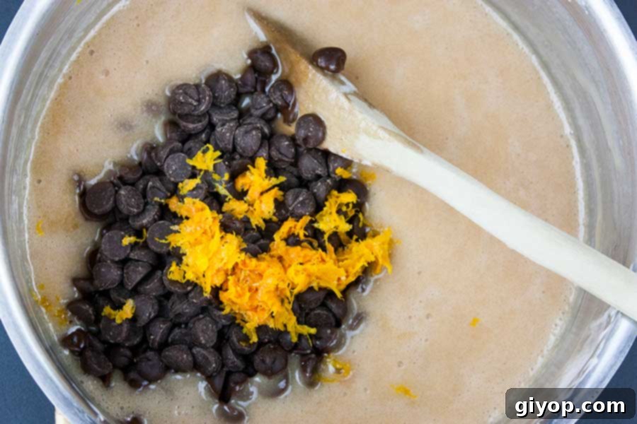 Ingredients for chocolate orange fudge simmering gently in a saucepan, highlighting the cooking process.
