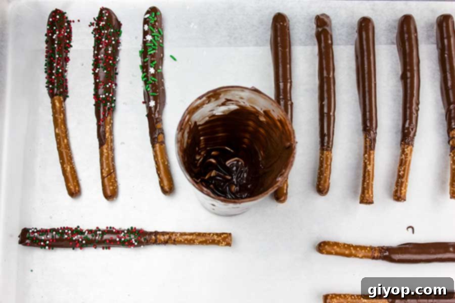 Dark Chocolate Covered Pretzel Rods on a parchment paper baking sheet.