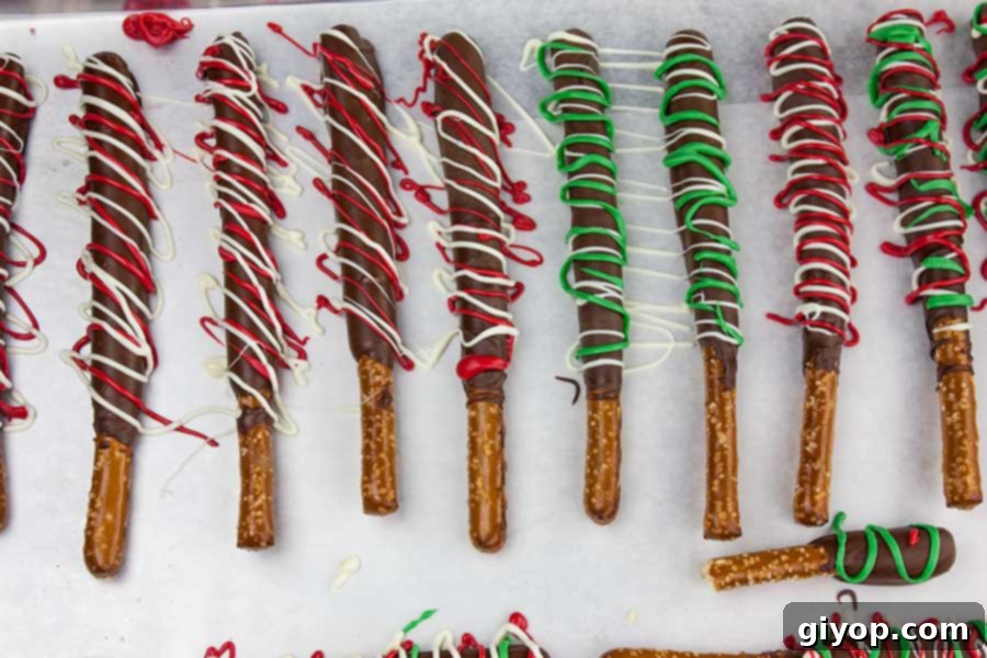 Dark Chocolate Covered Pretzel Rods on a parchment paper lined baking sheet.