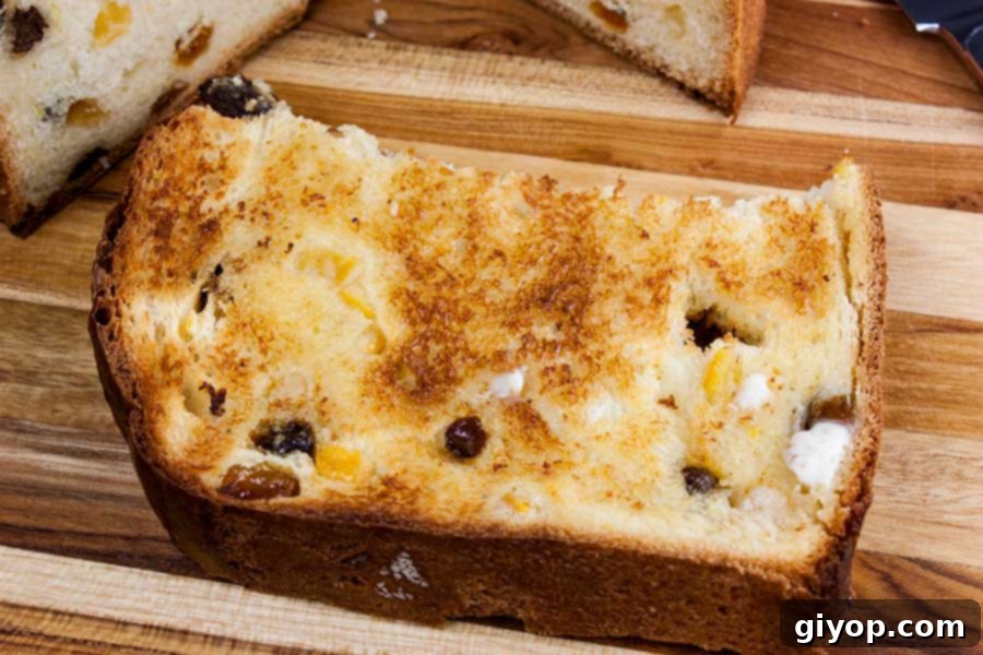 Toasted and buttered slice of panettone bread on a wooden board.