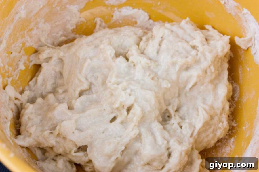 Panettone starter ingredients mixed in a yellow bowl before rising.